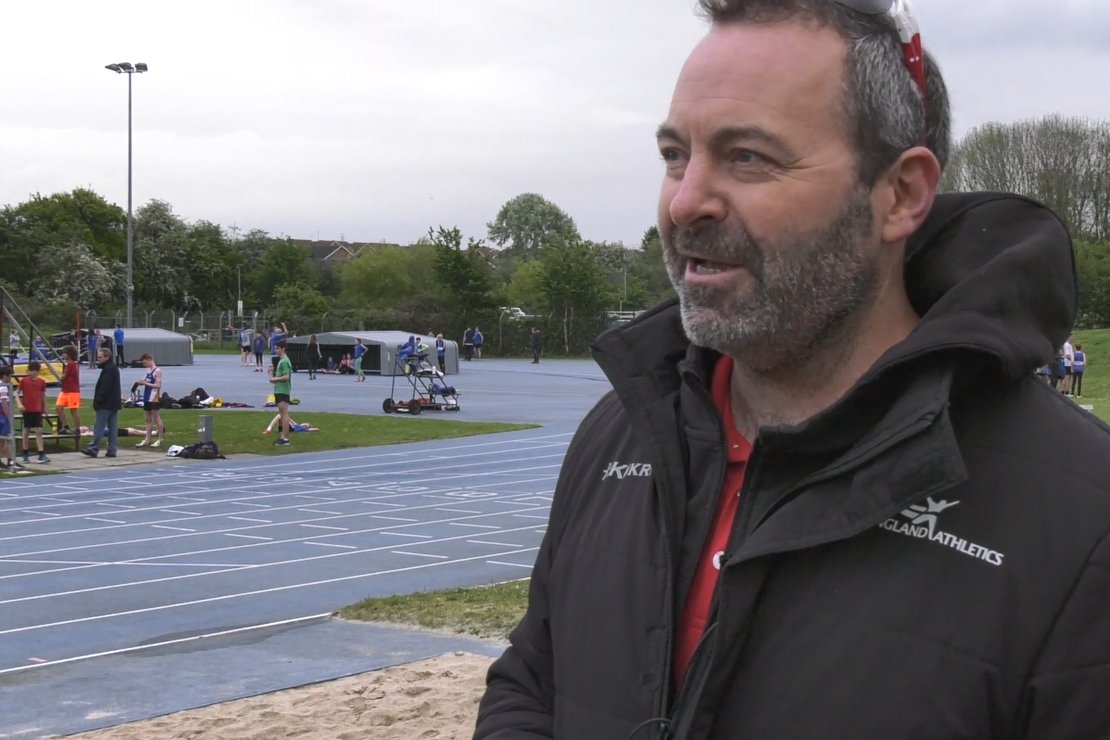 Chris Jones standing next to a running track.